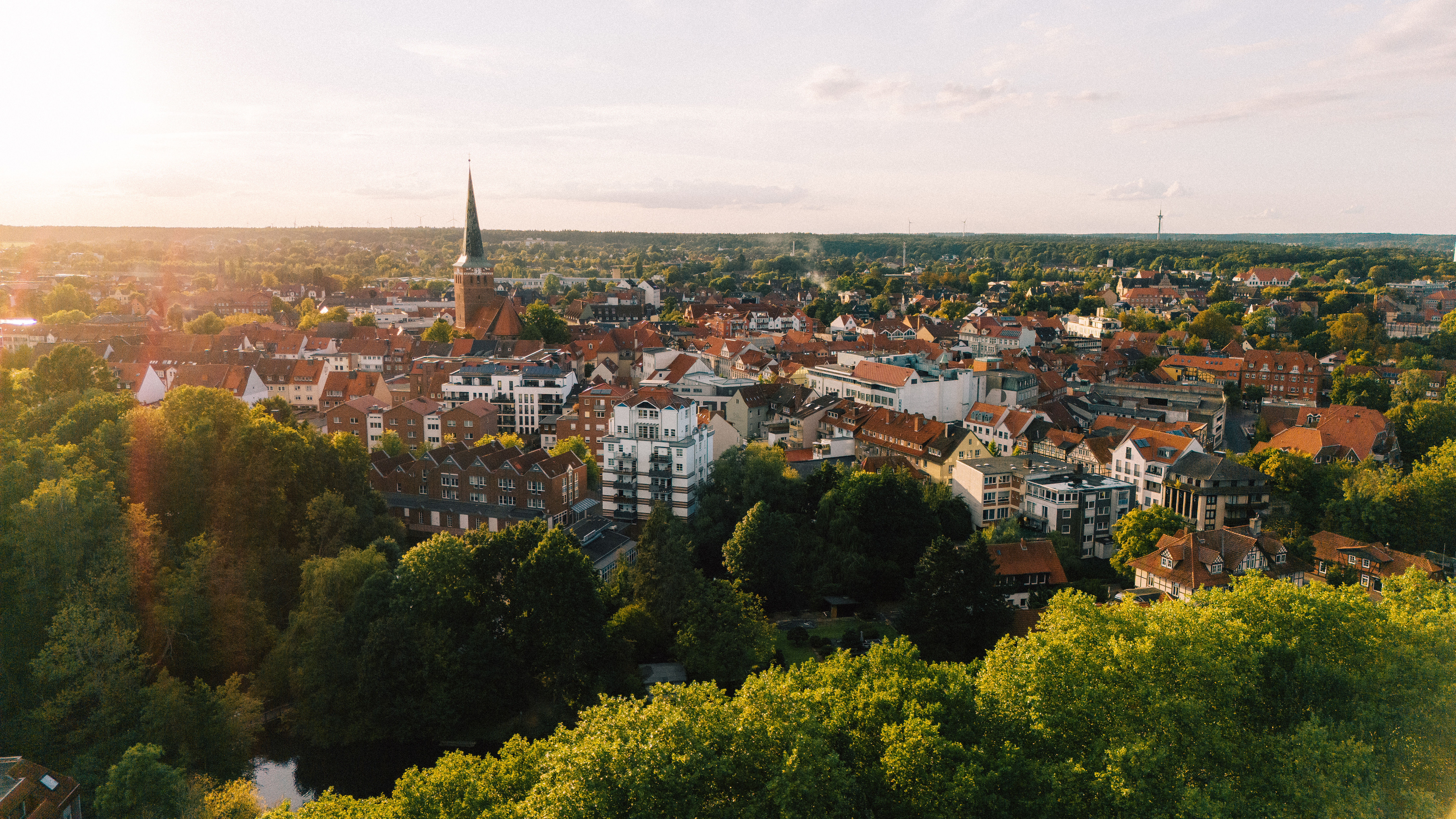 Luftaufnahme der Uelzener Skyline mit Häusern & Kirche zwischen vielen Bäumen.