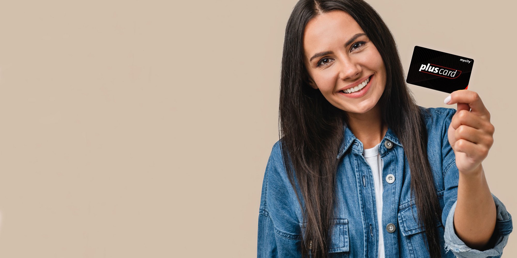 Eine Frau hält lächelnd eine mycity pluscard in die Kamera, beiger Studio Hintergrund.