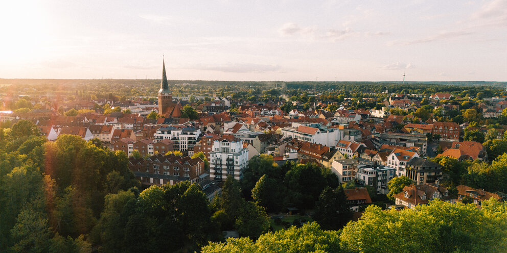Luftaufnahme der Uelzener Skyline mit Häusern & Kirche zwischen vielen Bäumen.
