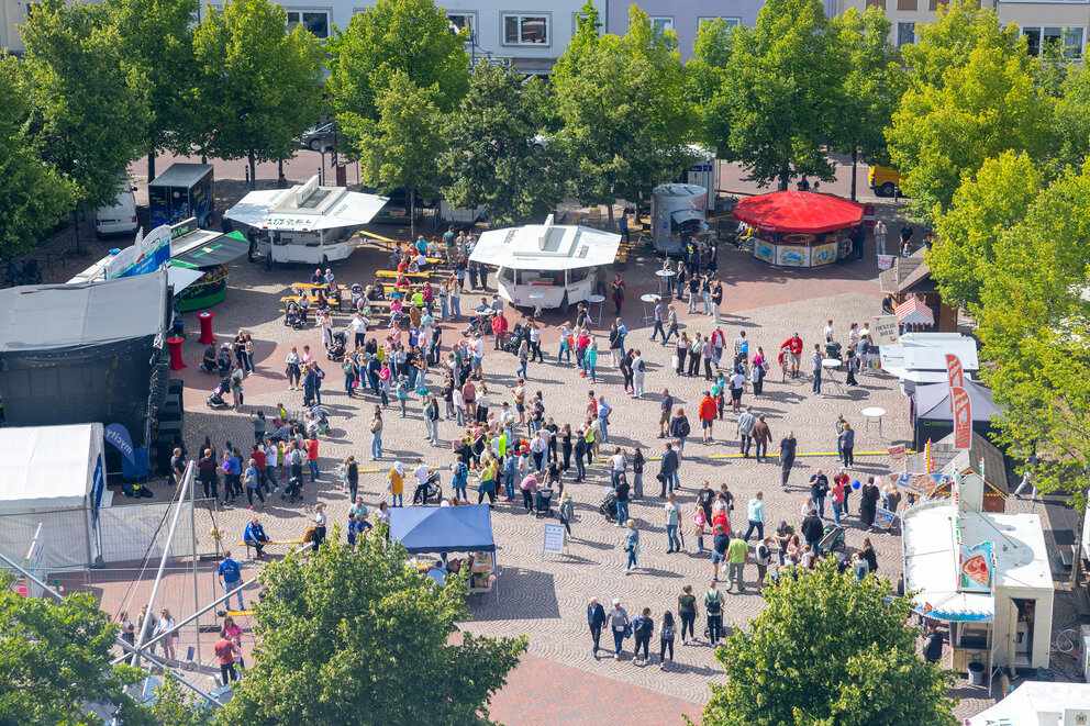 Aus der Vogelperspektive ein großer Marktplatz mit einigen Bierständen und Zelten sowie vielen Menschen darauf.