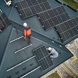 Eine Photovoltaik Anlage aus der Vogelperspektive, die auf mehreren Dächer des Hauses montiert ist.