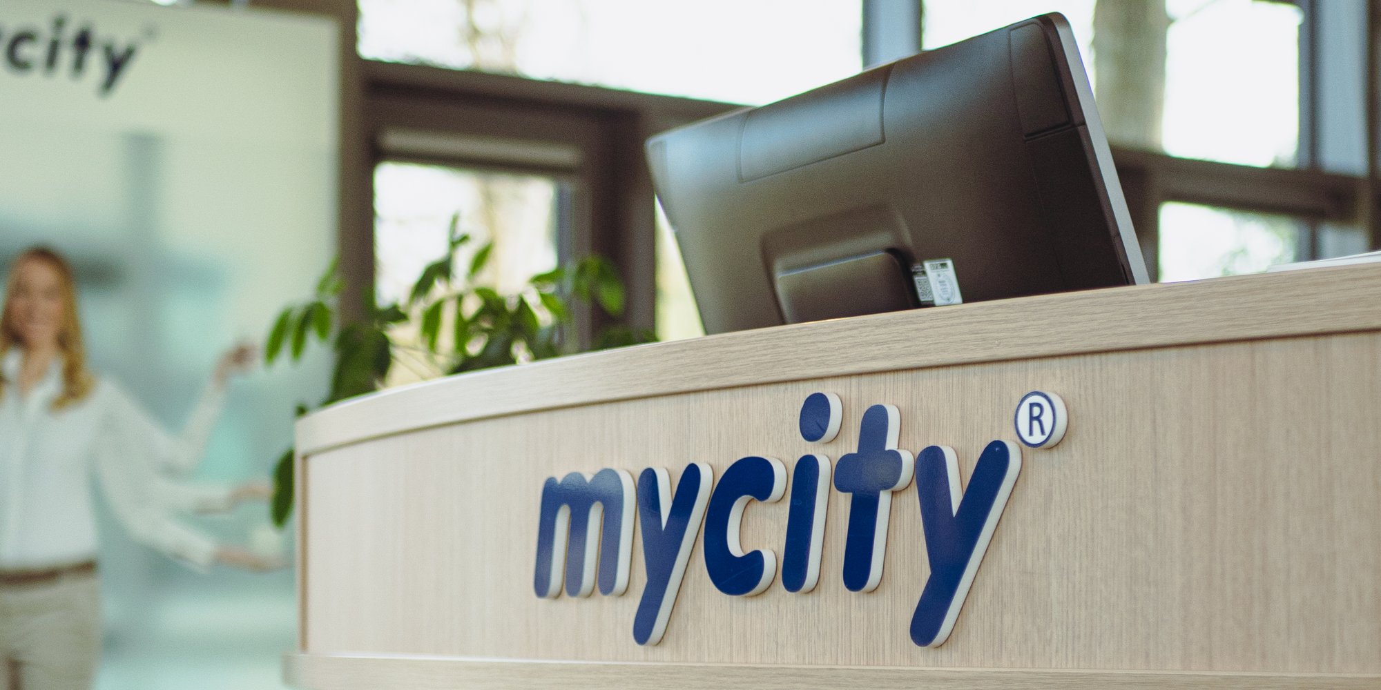 Ein Service Center Desk mit dunkelblauem Schriftzug mycity darauf und einigen Motiven darunter.