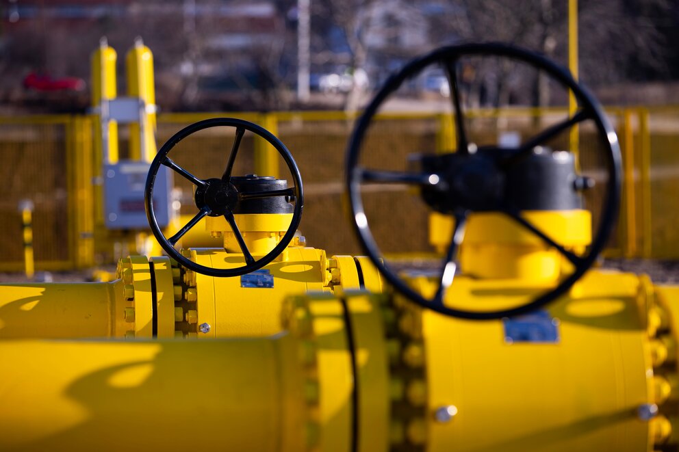 Zwei große Gasrohre in gelb stehen voreinander, mit Fokus auf den schwarzen Rädern zum Aufdrehen.