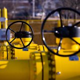 Zwei große Gasrohre in gelb stehen voreinander, mit Fokus auf den schwarzen Rädern zum Aufdrehen.